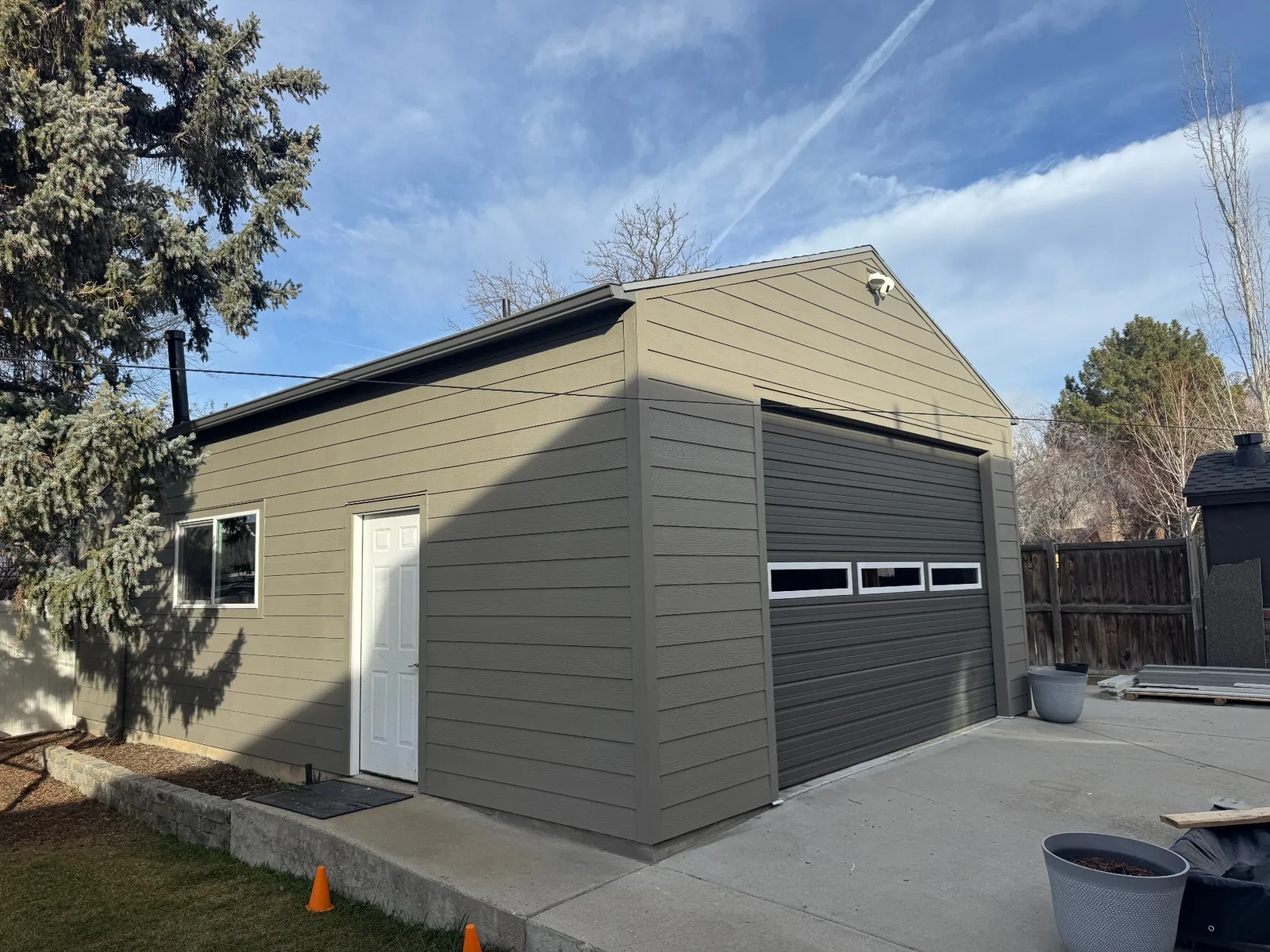 Detached garage with new warm-gray lap siding installed by Signature Roofing & Exteriors