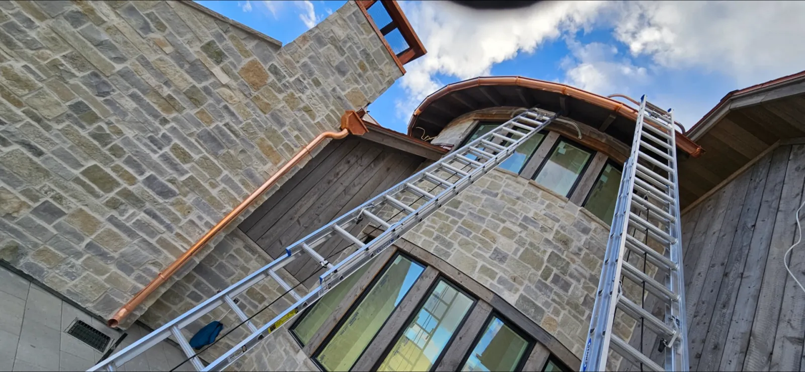 Natural stone exterior with copper gutter and board-and-batten siding on a Utah home
